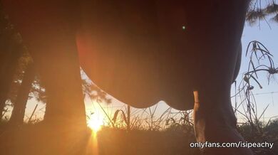 girl peeing with the sunset in the field
