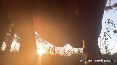 girl peeing with the sunset in the field