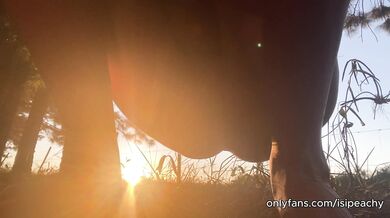 girl peeing with the sunset in the field