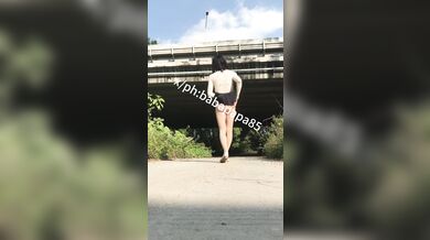 sissy in red bottom high heels and white hollow top exposes herself and pees under highway bridge