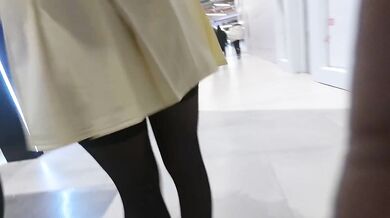 A girl walks in a short skirt without panties in a shopping mall
