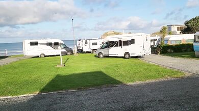 Trashy MILF slut pisses on the grass in front of other campers at the beach