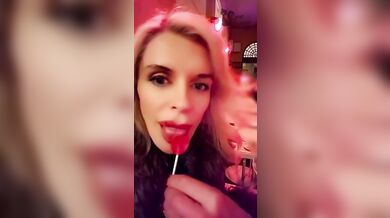 Hot blonde milf sexily sucks a lollipop in front of everyone in a cafe