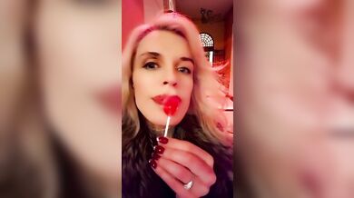 Hot blonde milf sexily sucks a lollipop in front of everyone in a cafe