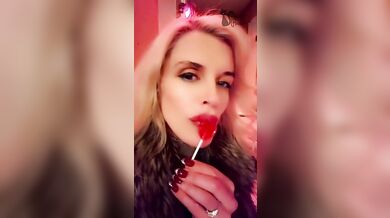 Hot blonde milf sexily sucks a lollipop in front of everyone in a cafe