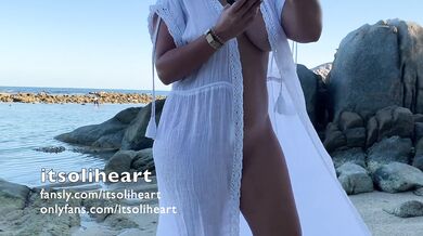 PUBLIC BEACH - naked young woman applying suncream