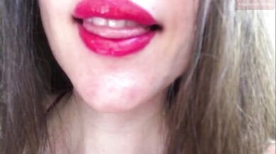 Innocent girl teasing with her fat lips, putting on red lipstick, sensually biting her lips, sucking