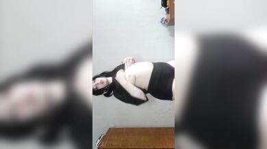 A brunette woman massages her body with pleasure.