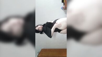 A brunette woman massages her body with pleasure.