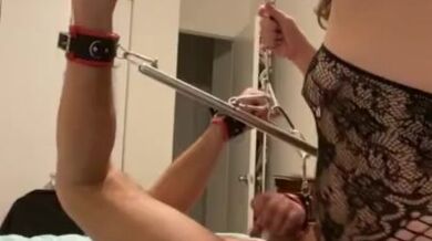 Femdom pegging sub locked in spreader bar chained to the ceiling