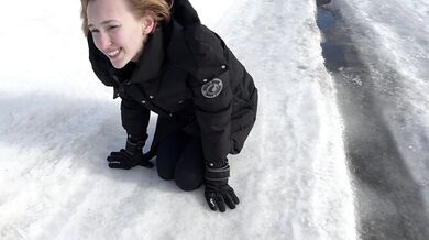The girl is trying to walk on ice in ballet boots, but her toes are very painful