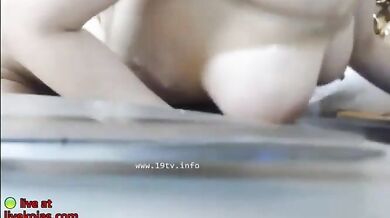 Busty Asian redhead oils her big tits